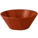 A copper serving bowl with a red rim.