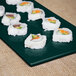 A plate of sushi on a Tablecraft hunter green and white speckled rectangular metal cooling platter.