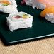 A Tablecraft rectangular cast aluminum platter with sushi on it.