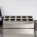 A Steril-Sil stainless steel countertop flatware organizer with 10 cylinders with holes in it.