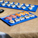 A Tablecraft blue speckle metal rectangular platter holding sushi.