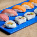 A Tablecraft blue speckled rectangular cast aluminum platter with sushi on it.