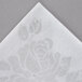 A white Hoffmaster Linen-Like dinner napkin with a rose design.