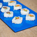 A Tablecraft blue speckle cast aluminum rectangular cooling platter with sushi rolls on it.