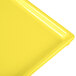 A yellow cast aluminum Tablecraft rectangular cooling platter with a white edge.