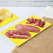 Two yellow Tablecraft cast aluminum rectangular cooling platters with meat and cheese on a counter.