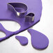A purple piece of dough being cut with metal Ateco comma cutters.