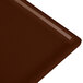 A close-up of a brown surface on a Tablecraft brown cast aluminum rectangular cooling platter.