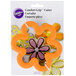 A Wilton comfort grip flower cookie cutter in a package.
