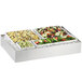 A Cal-Mil stainless steel ice housing tray filled with food.