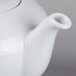 A close-up of a white Schonwald teapot with a lid.