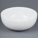 A CAC white porcelain salad bowl on a gray surface.
