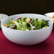 A close-up of a bowl of green salad in a white CAC porcelain bowl.