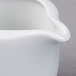 A close up of a Schonwald white porcelain sauce boat with a curved handle.