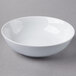 A Schonwald round white porcelain bowl on a gray surface.