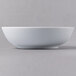 A Schonwald round white porcelain bowl on a gray surface.