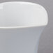 A close up of a Schonwald white porcelain creamer with a small handle.