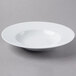A Schonwald white porcelain bowl with a white rim on a gray surface.