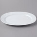 A Schonwald white porcelain oval platter with a thin rim on a gray surface.