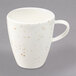 A white porcelain cup with brown specks.