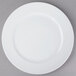 A Schonwald white porcelain plate with a white rim on a gray surface.
