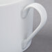 A close-up of a Schonwald Continental white porcelain cup with a handle.