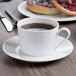 A Schonwald Continental white porcelain cup of coffee on a saucer with bread