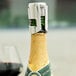 A Tablecraft 398 champagne stopper on a bottle of champagne with a cork.