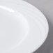 A close-up of a Schonwald Donna white porcelain plate with a curved edge.