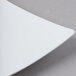 A close-up of a Schonwald white porcelain coupe plate with a curved edge.