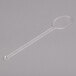 A clear plastic WNA Comet mixed drink stirrer with an oval spoon on a long handle.