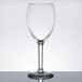 A clear Libbey tall wine glass with a stem on a table.