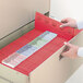 A hand opening a drawer with red Smead TUFF file folders inside.