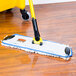 A Rubbermaid Flow nylon finishing pad in blue and white on a wood floor.