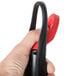 A hand holding a black and red Rubbermaid spray mop handle.