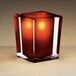 A Sterno square glass candle holder with a red candle inside.