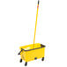 A yellow Rubbermaid mop bucket with a handle and wheels.