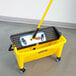 A Rubbermaid yellow mop in a yellow bucket with a handle.