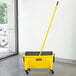 A yellow Rubbermaid mop bucket with a handle on the side.