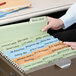 A person holding a Smead FasTab file folder with many different colored files.