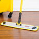 A Rubbermaid yellow microfiber wet mop pad with a yellow hook and loop.