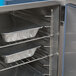 A metal cabinet with trays of food inside an Alto-Shaam stackable oven.