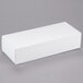 A white rectangular 3 lb. candy box with a lid on a gray surface.