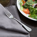 A Libbey stainless steel salad fork on a plate of salad.