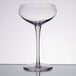 A clear wine glass with a long stem on a table.