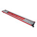 A red and silver rectangular metal piece with a long handle and curved top with a red light inside.