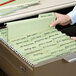 A hand putting a Smead FasTab file into a file drawer.