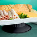 A tray of food on a GET Melamine pedestal stand with sliced ham, bread, and cheese.