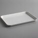 A white rectangular Cambro market tray with a handle on a gray surface.