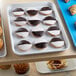 A white Cambro market tray of cookies and pastries on a table.
